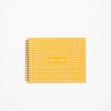 Yellow grid notebook with 'MEAL PLAN' text on a white background