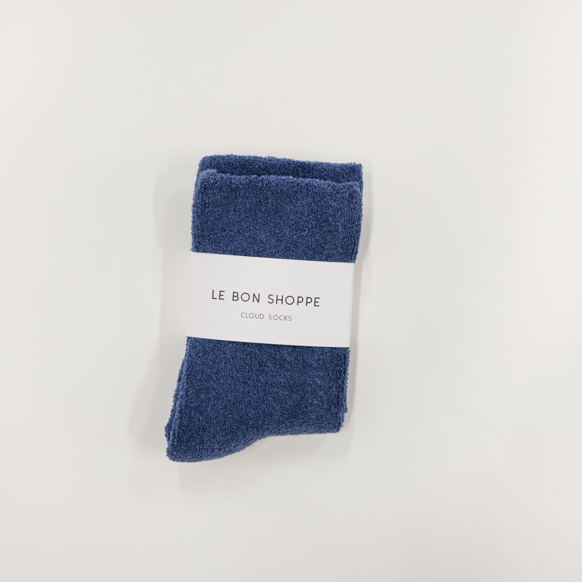 navy cloud socks on a white surface, each with a label indicating the brand le bon shoppe