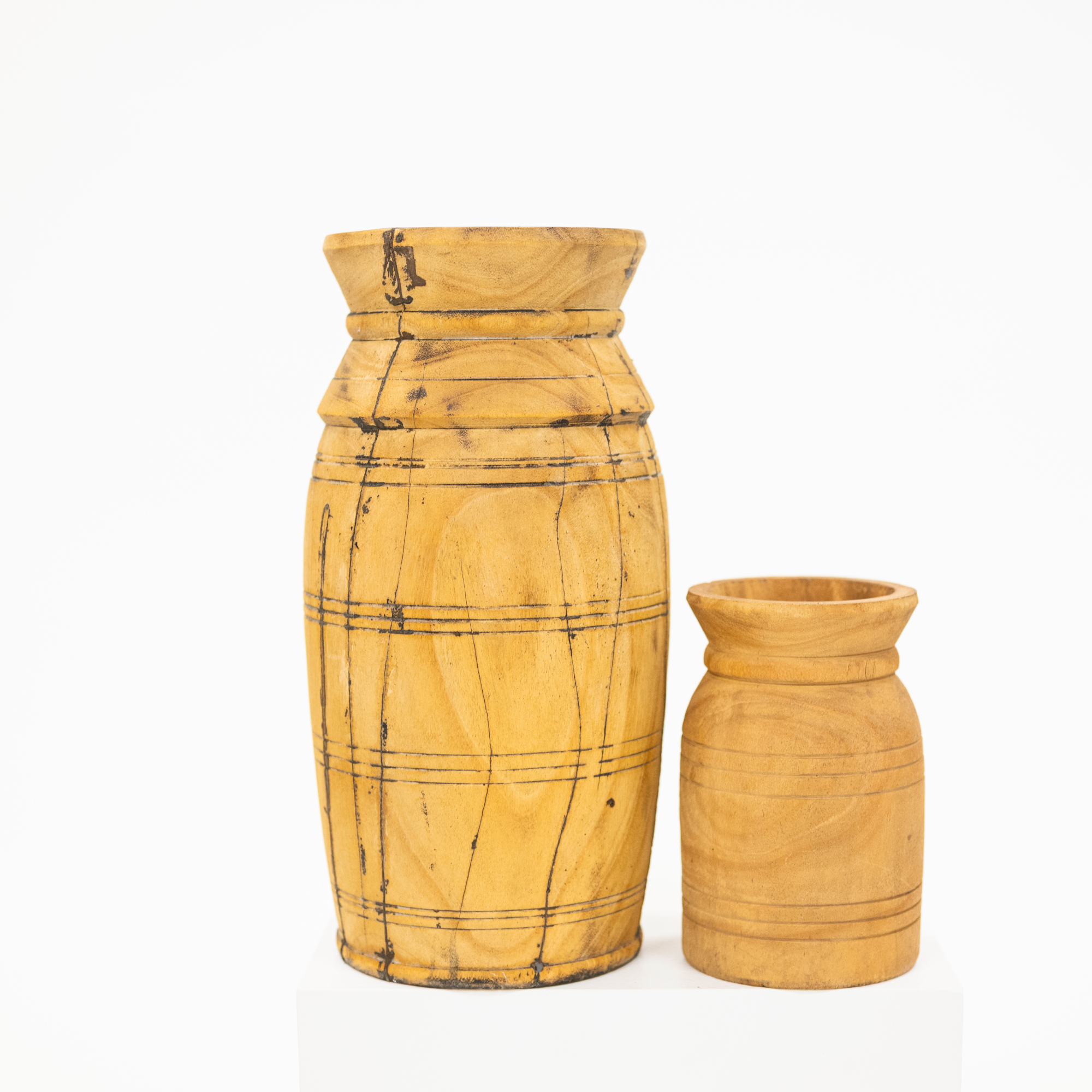 Two hand-carved wooden vases in natural light wood with dark engraved lines, displayed on a clean white background.