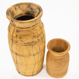 Two handcrafted wooden vases in natural light brown wood tones, featuring one tall vase with dark engraved lines and one smaller matching cup, set against a plain white background.
