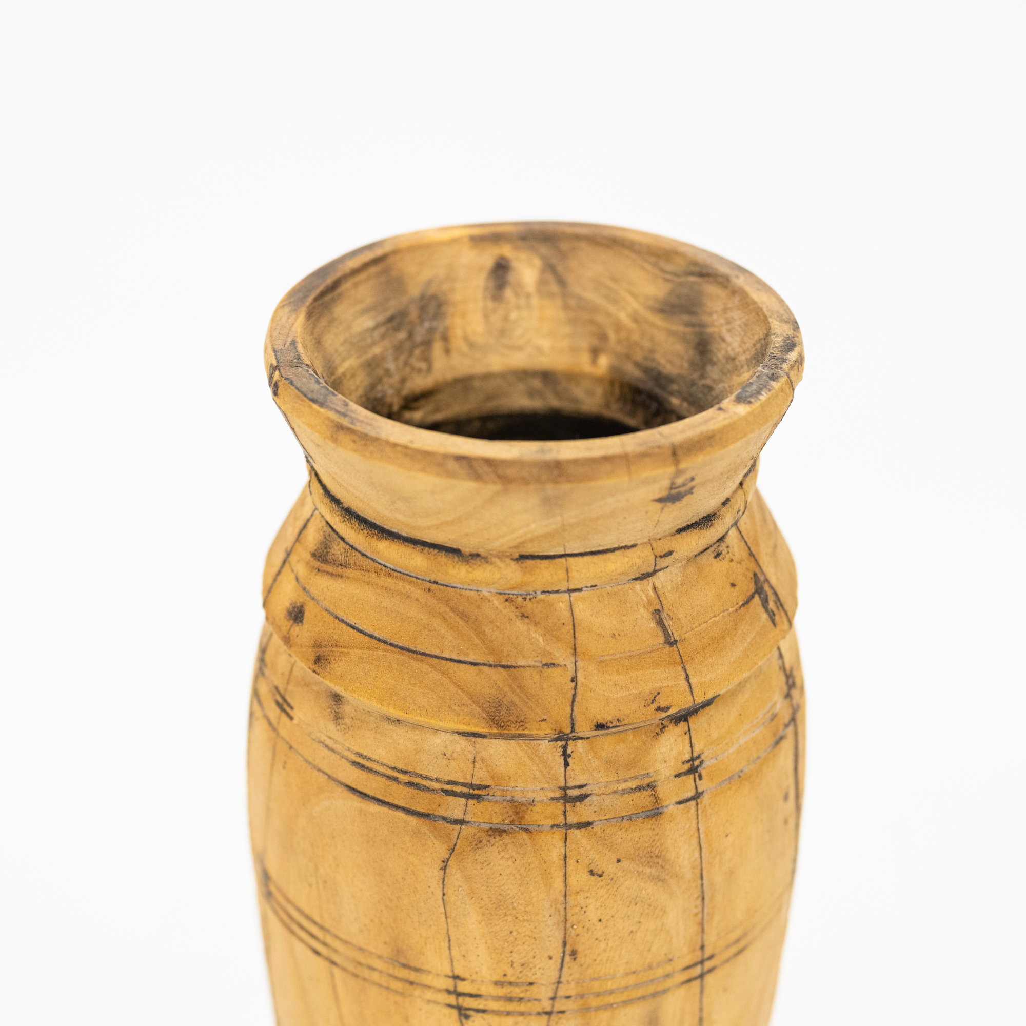 A close-up of a rustic wooden vase with a flared rim and carved horizontal grooves, showing natural wood grain and dark fissures, set against a plain white background.