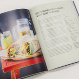 Open cookbook showing a recipe for spicy burritos with beef, avocado, and beans.