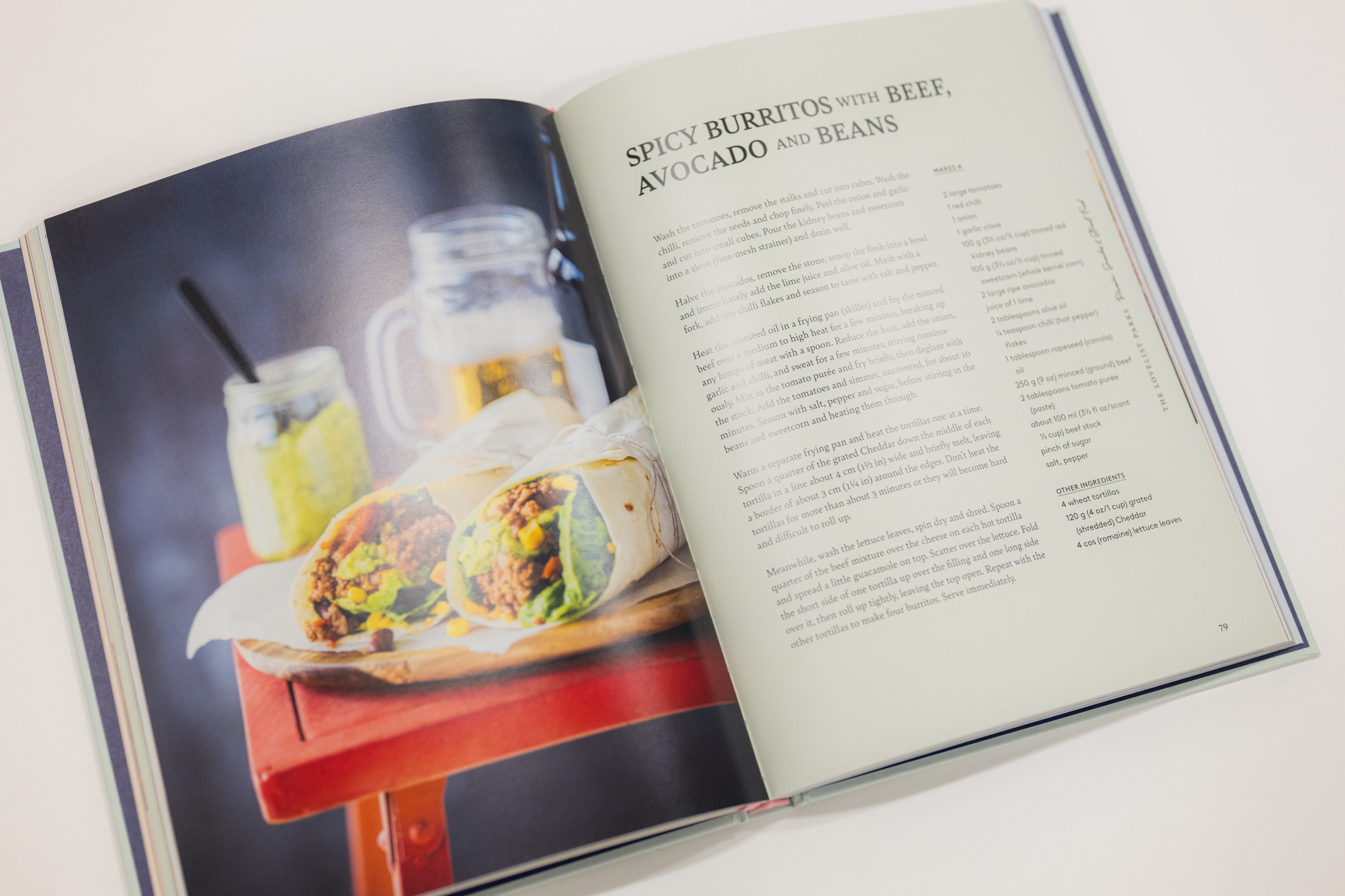 Open cookbook showing a recipe for spicy burritos with beef, avocado, and beans.
