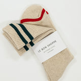 Pair of beige socks with green and red stripes on a white background, featuring 'Le Bon Shoppe' label.