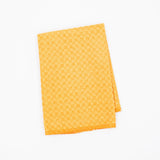 A folded yellow ochre microfiber dishcloth featuring a subtle checkerboard pattern, shown on a plain white background.