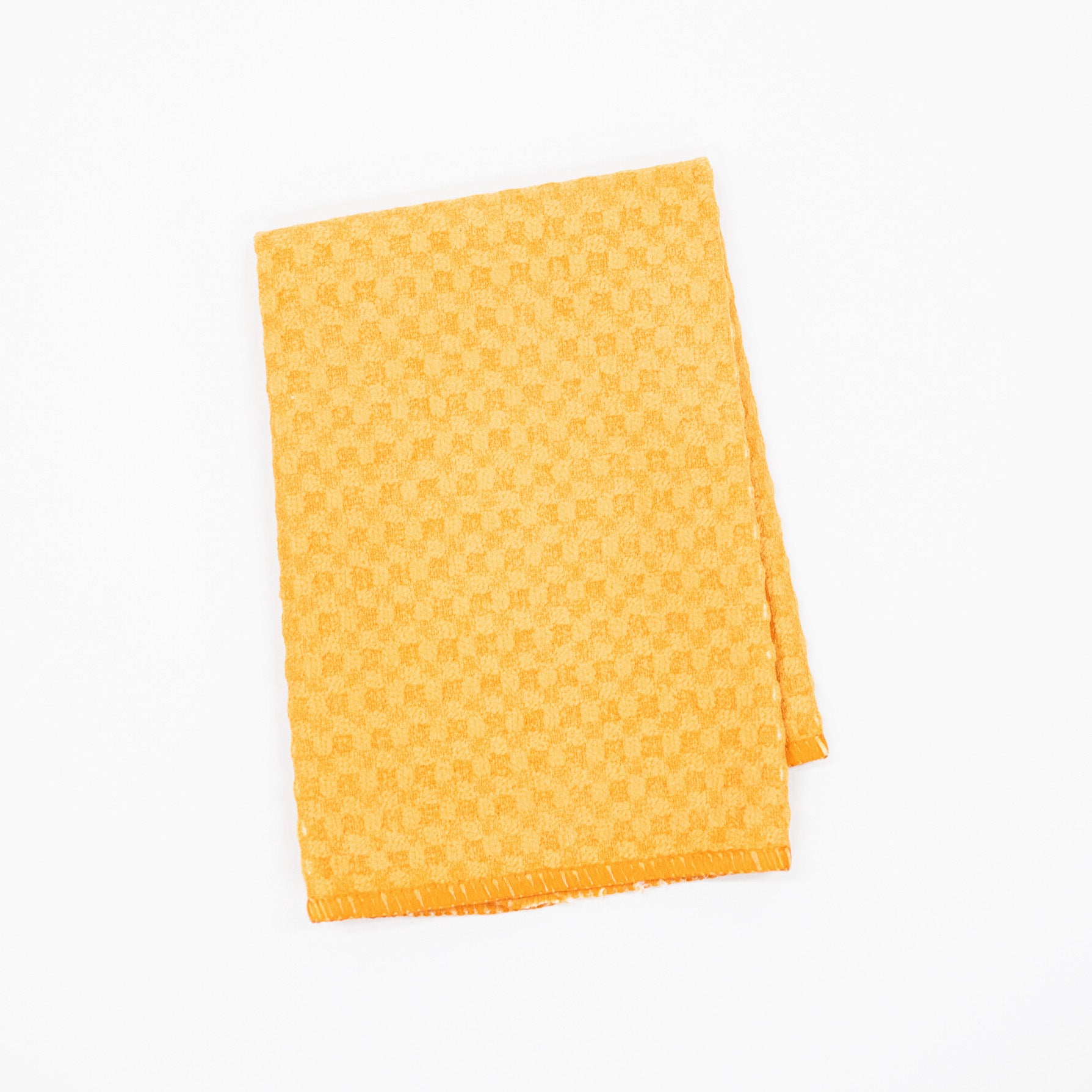 A folded yellow ochre microfiber dishcloth featuring a subtle checkerboard pattern, shown on a plain white background.