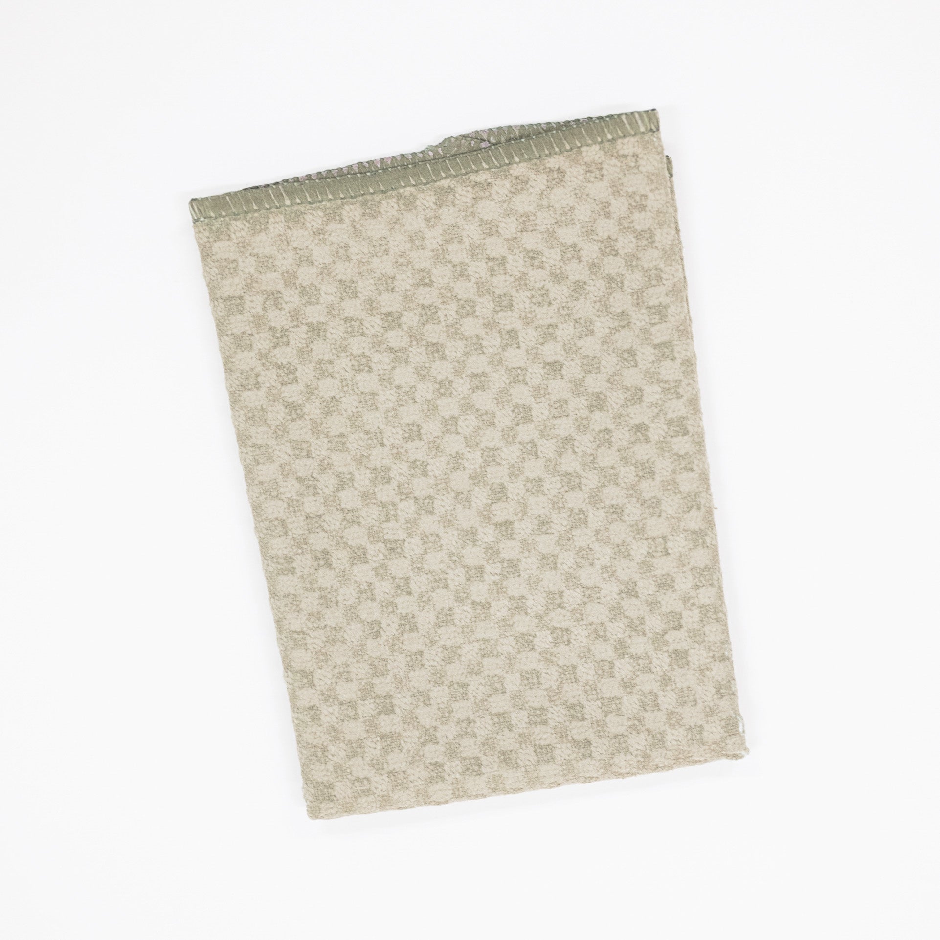 A folded microfiber dishcloth with a small-scale geometric checkered pattern in beige and muted sage green, shown on a plain white background.