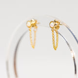 Gold hoop earrings with chain details on a light gray background