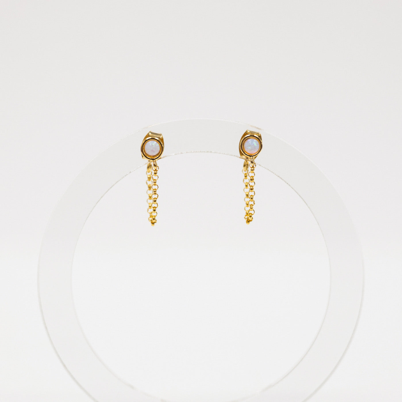 Gold chain earrings with a small round gemstone on a white background