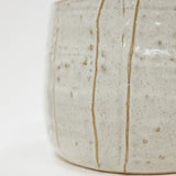 Close-up of a ceramic pot with a textured surface on a white background