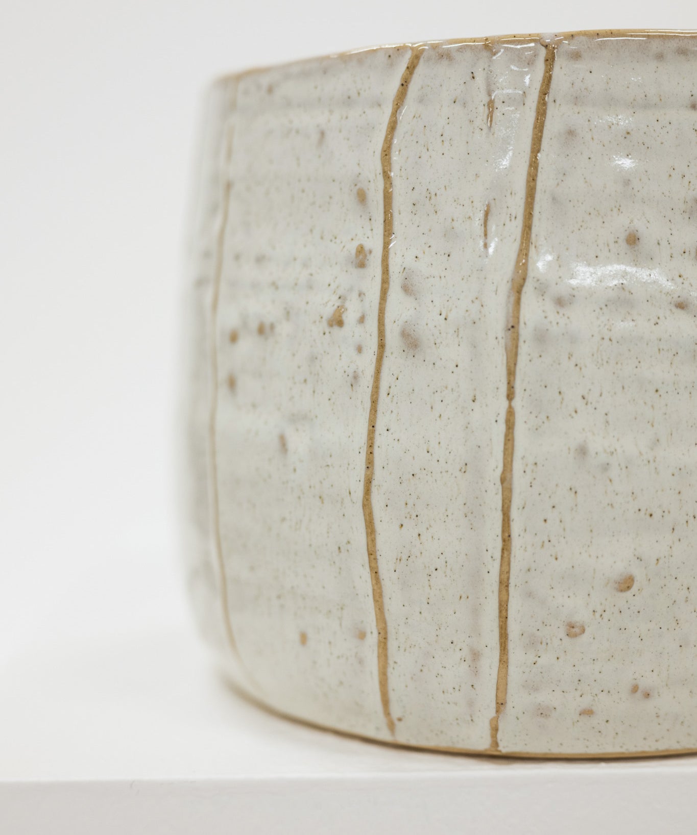 Close-up of a ceramic pot with a textured surface on a white background