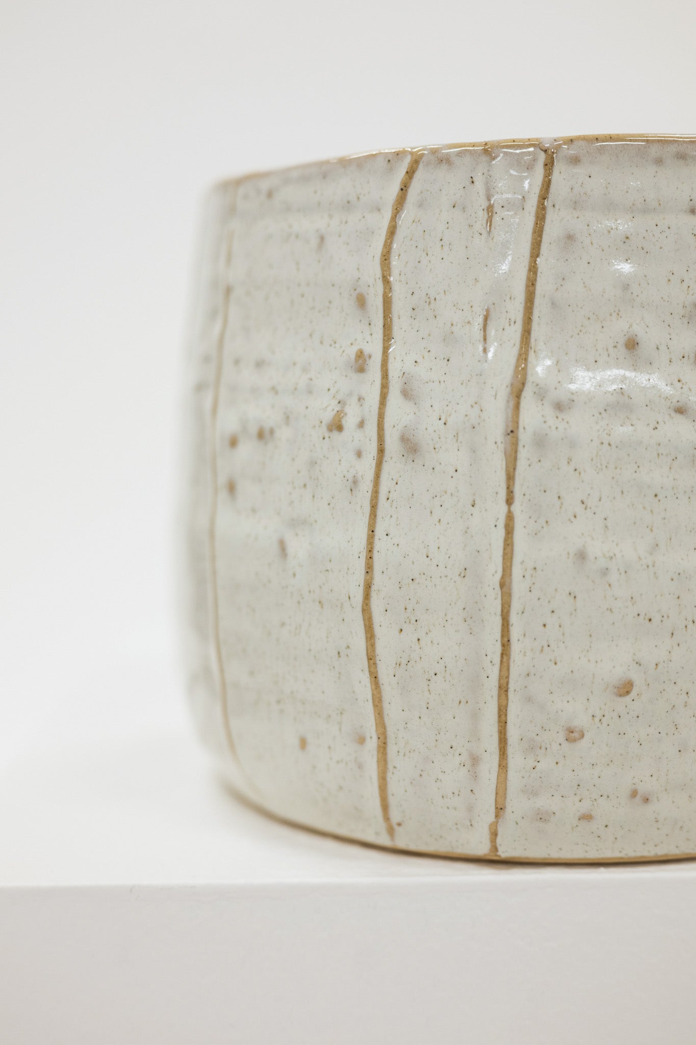 Close-up of a ceramic pot with a textured surface on a white background