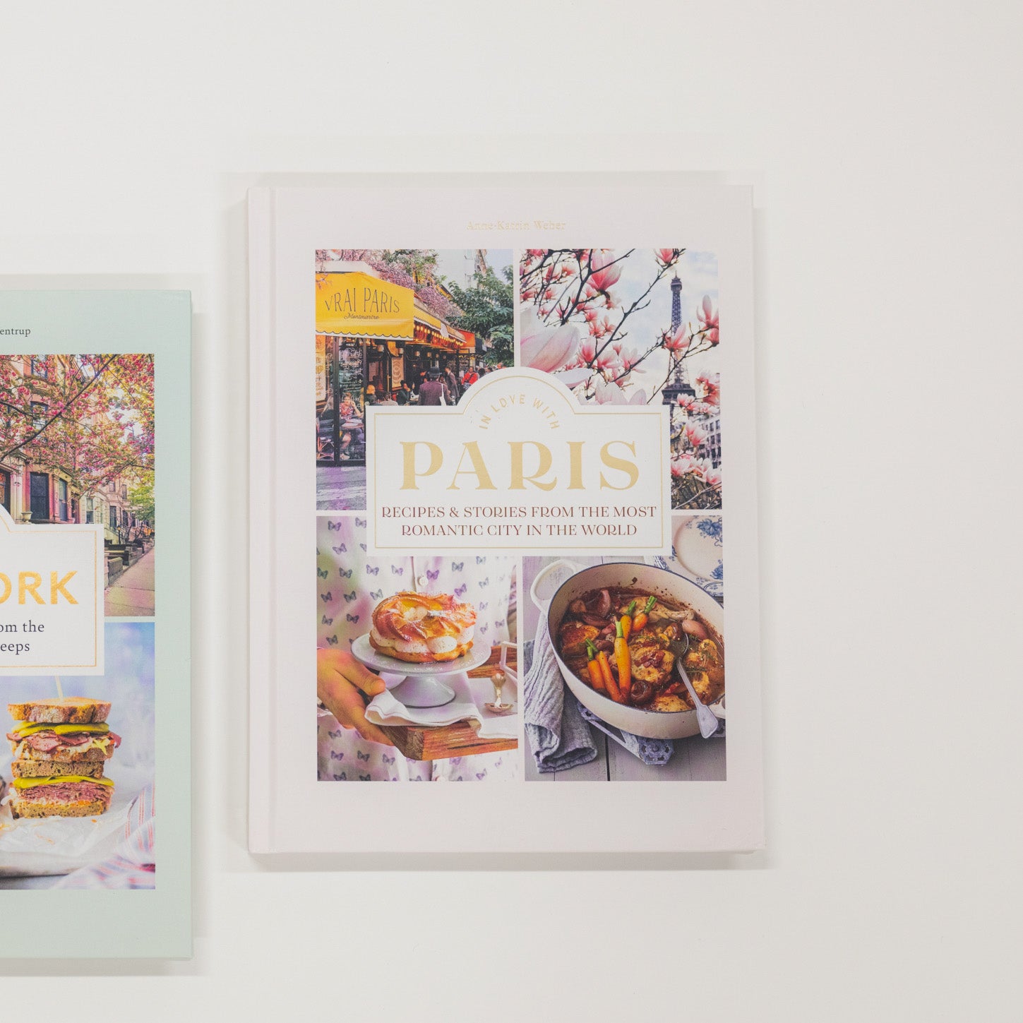 Cookbook titled 'Paris' with images of food and city scenes on a white surface.