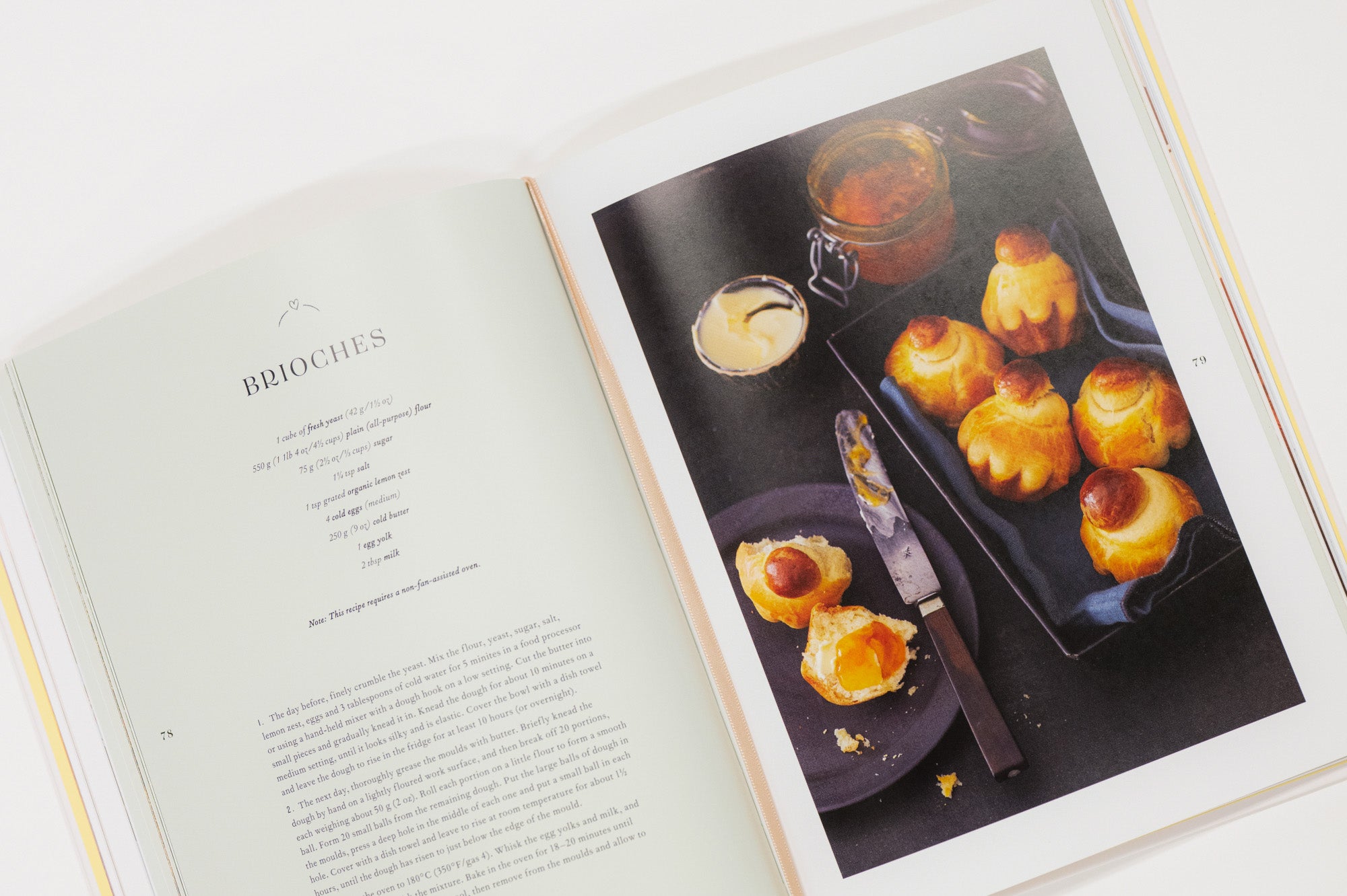 Open cookbook showing a page with a photograph of pastries on a white surface