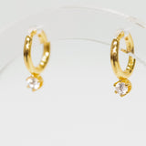 Gold hoop earrings with small CZ stud on a clear stand.