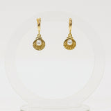 Gold shell earrings with pearl center on a white background