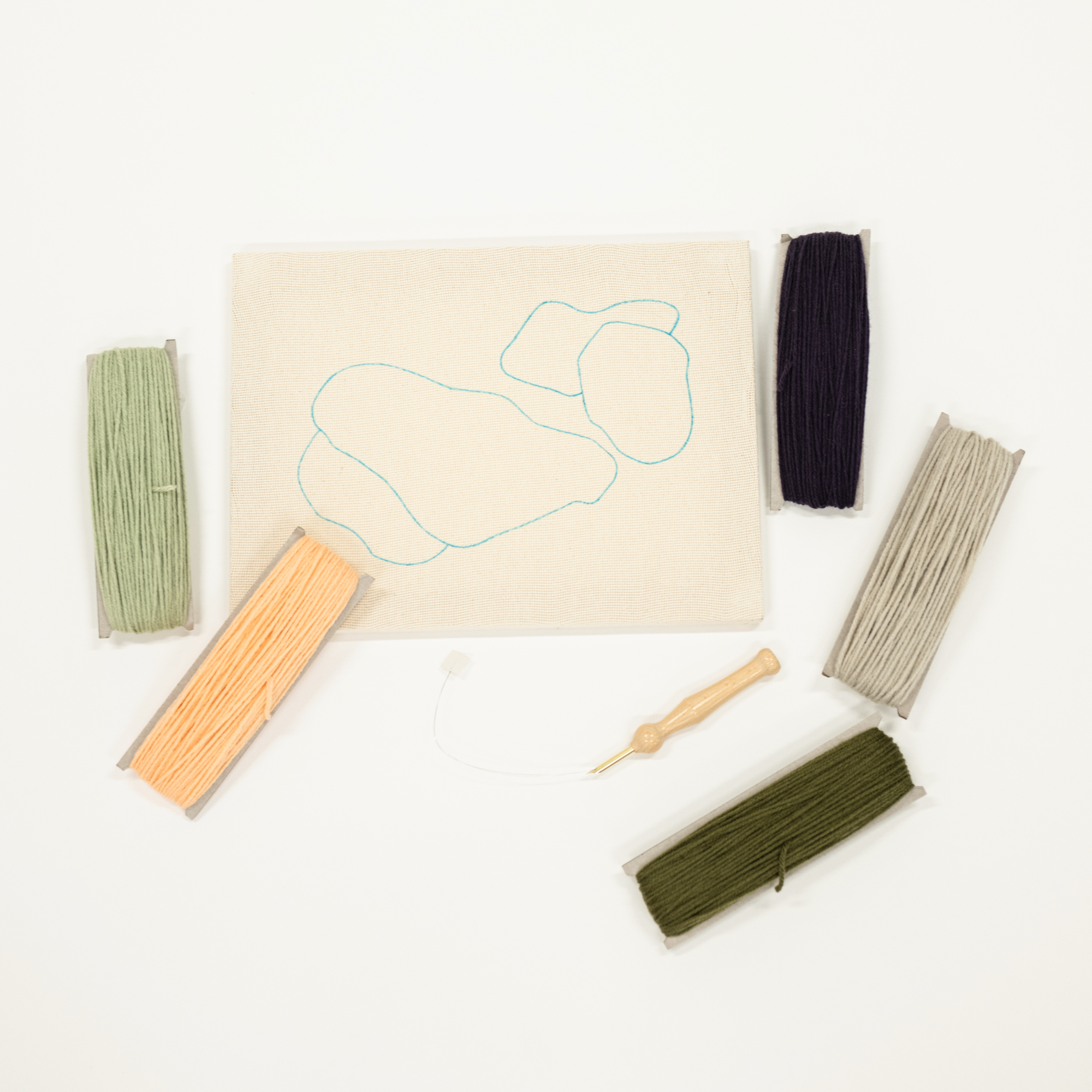 Set of embroidery threads and tools on a white background