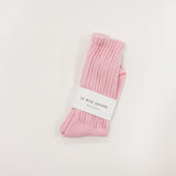 Pink ballet sock with a white label on a light gray background, le bon shoppe