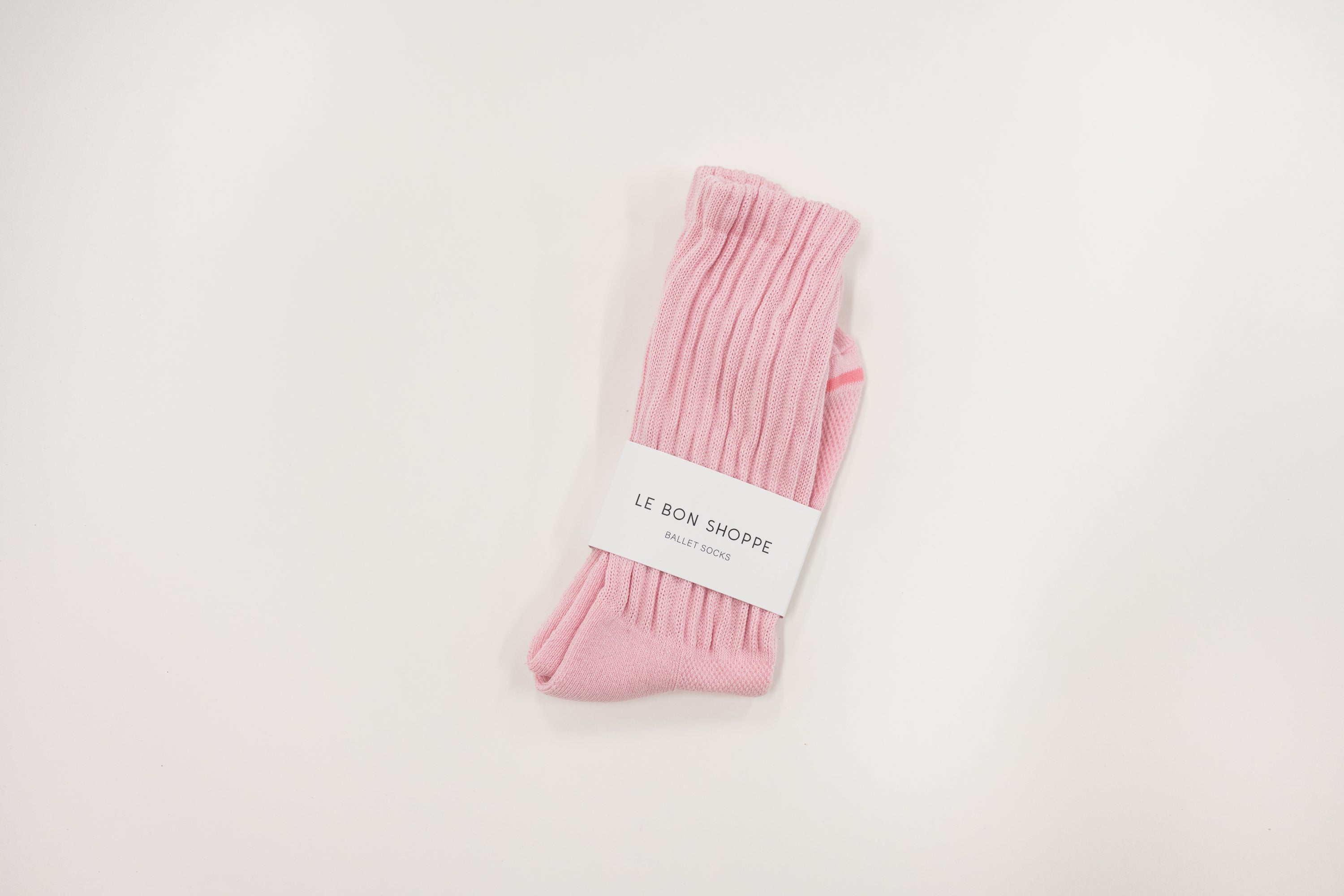 Pink ballet sock with a white label on a light gray background, le bon shoppe