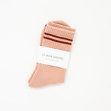 light pink boyfriend style crew sock with deep red stripe and white label saying le bon shoppe