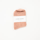 pink cloud socks on a white surface, each with a label indicating the brand le bon shoppe