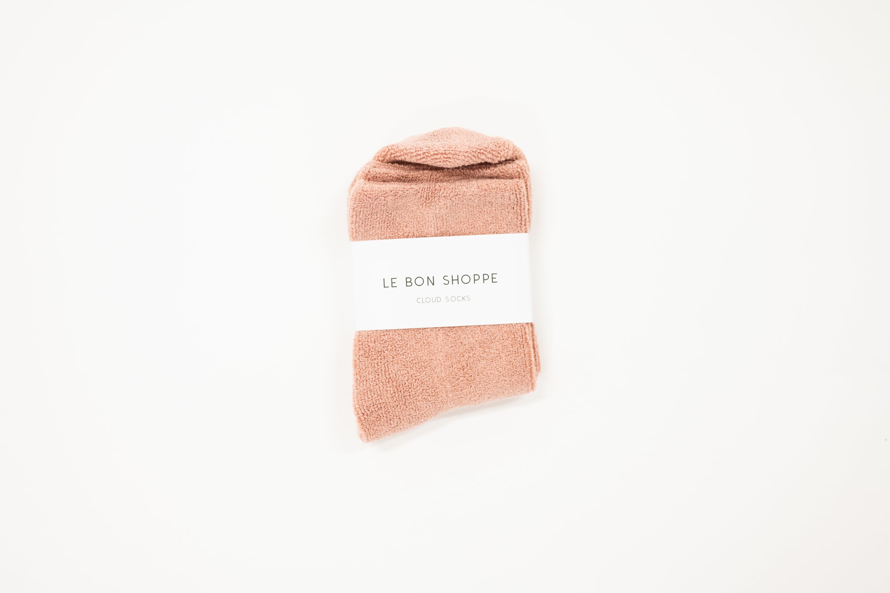 pink cloud socks on a white surface, each with a label indicating the brand le bon shoppe