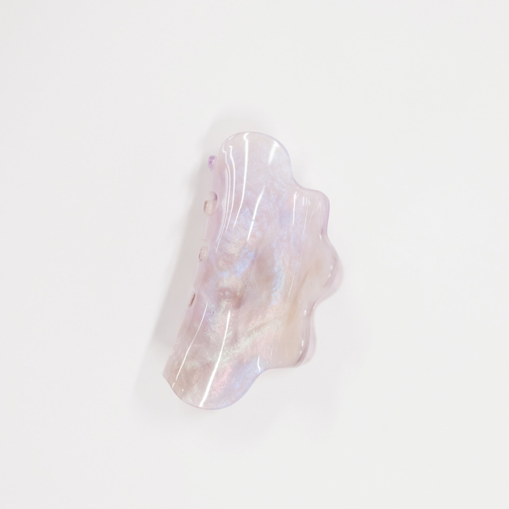 An organic-shaped resin hair claw clip with a pearlescent, iridescent finish showing soft lavender, pink, and white hues, set against a plain white background.
