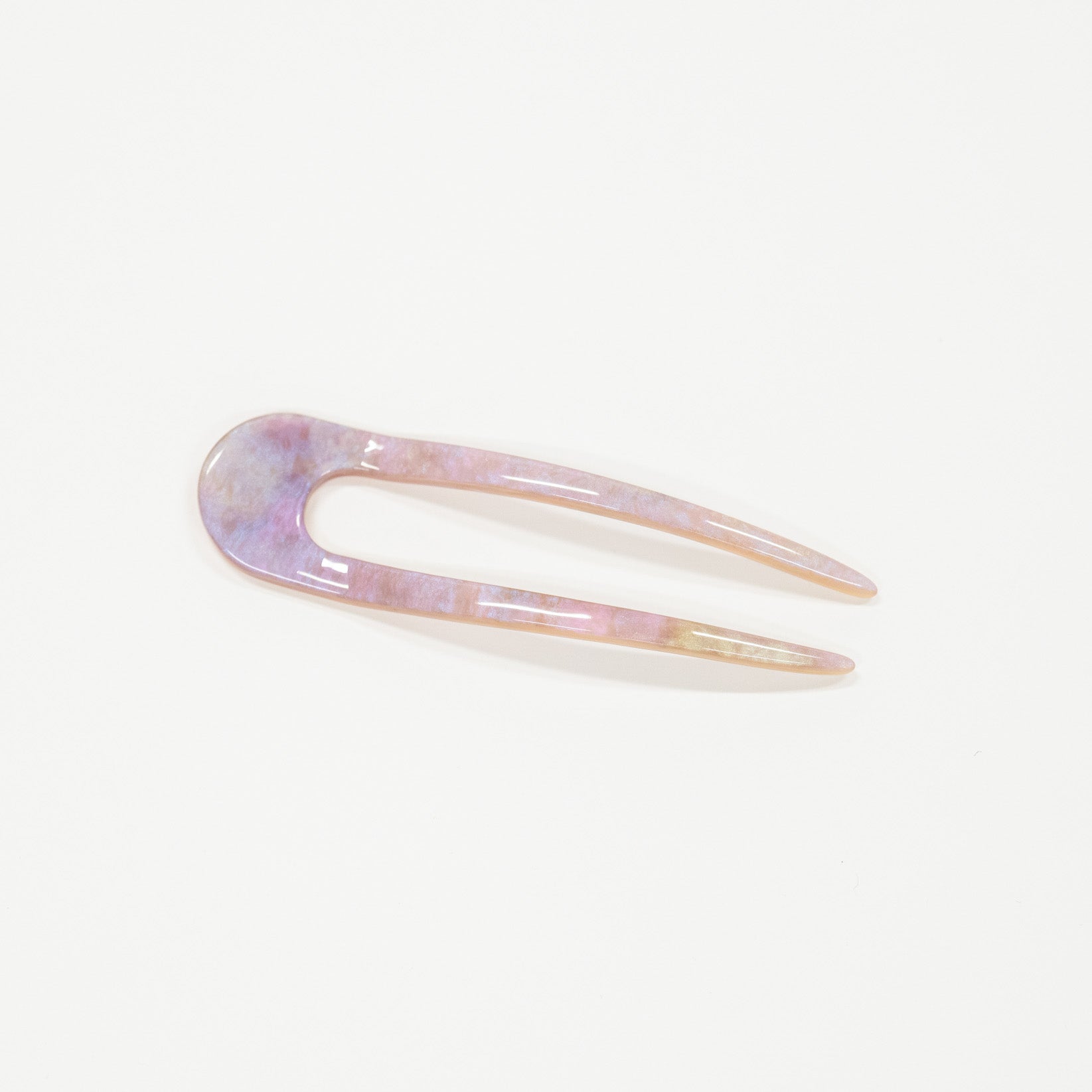 Iridescent hair clip on a light purple background