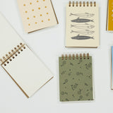 Collection of small notebooks with various designs on a white background