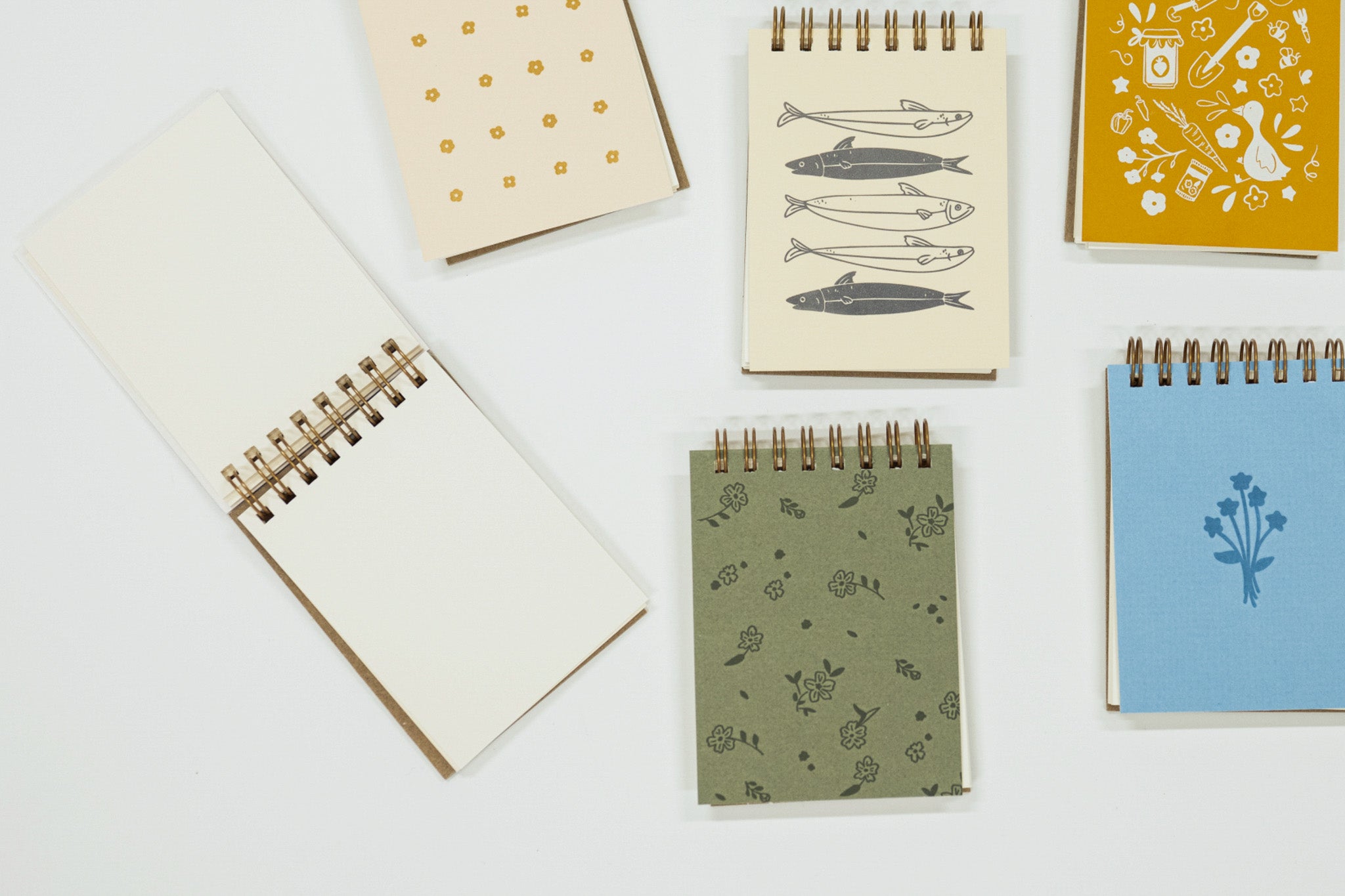 Collection of small notebooks with various designs on a white background