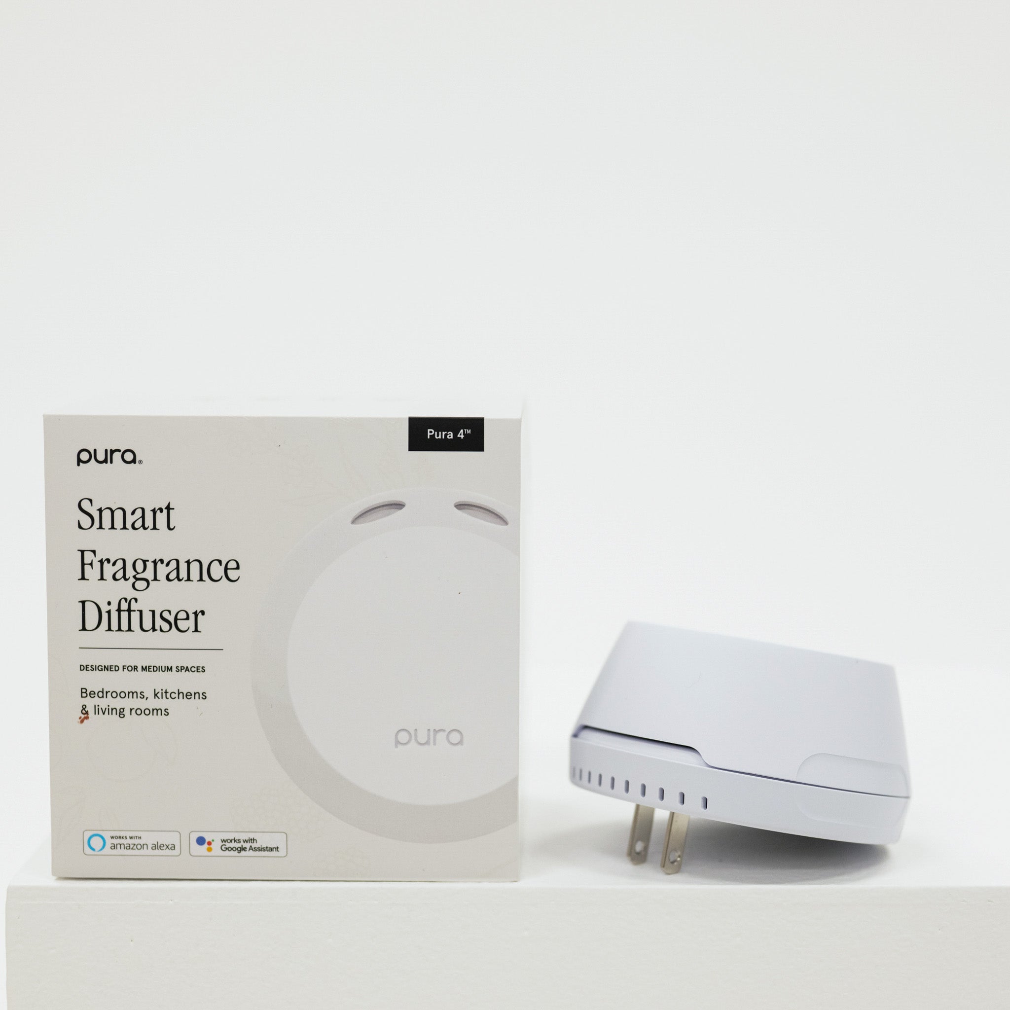 Pura smart fragrance diffuser with packaging on a white background