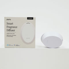Pura smart fragrance diffuser with packaging on a white background