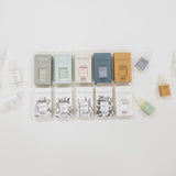 Various small boxes and bottles arranged on a light background