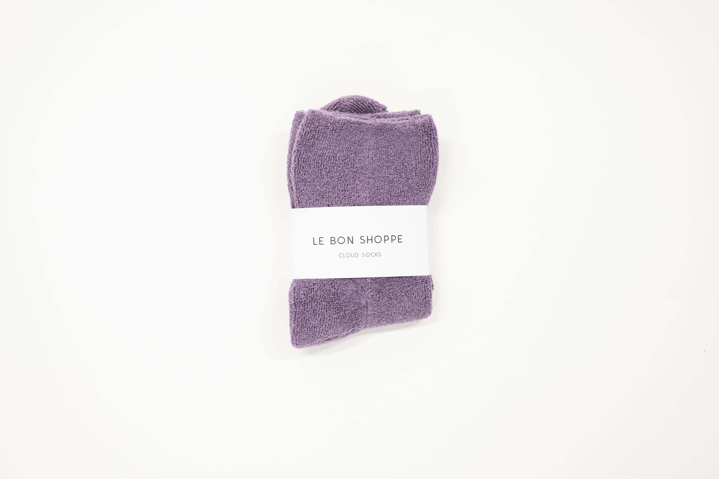 purple cloud socks on a white surface, each with a label indicating the brand le bon shoppe