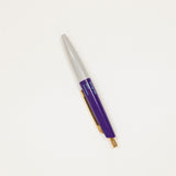 Pen with purple and gold accents on a white background