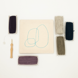 Embroidery kit with fabric, threads, and tools on a white background