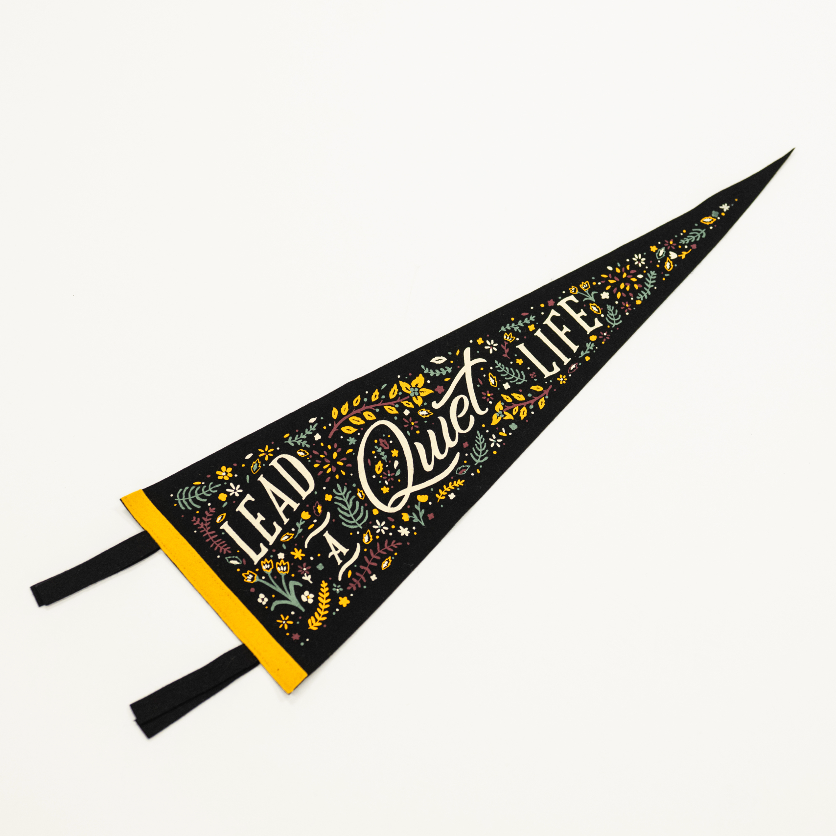 Decorative pennant with 'Lead a Quiet Life' text on a white background