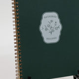 Green recipe book with floral design on a white background