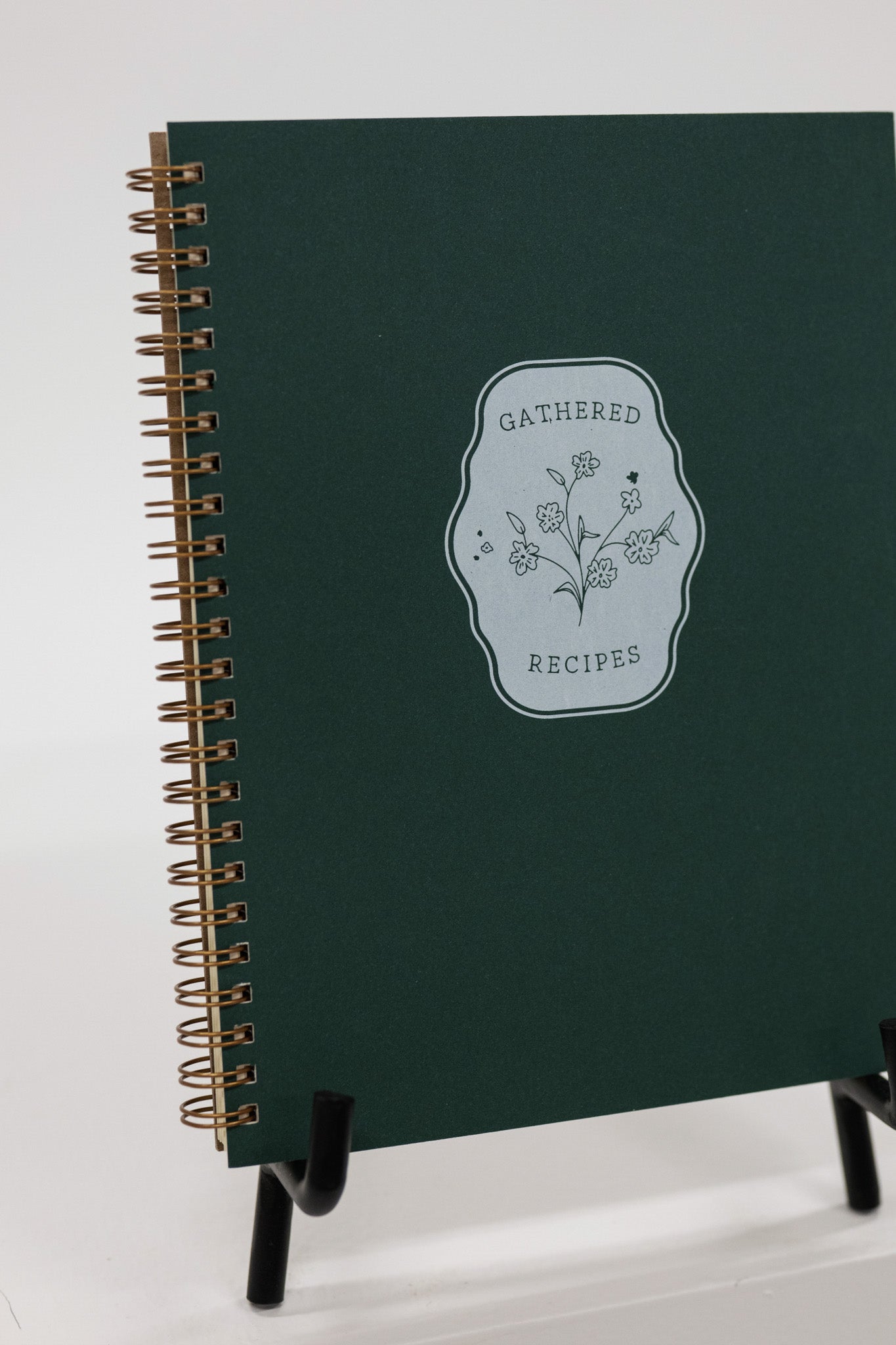 Green recipe book with floral design on a white background