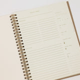 Open spiral-bound recipe notebook with lined pages on a white background