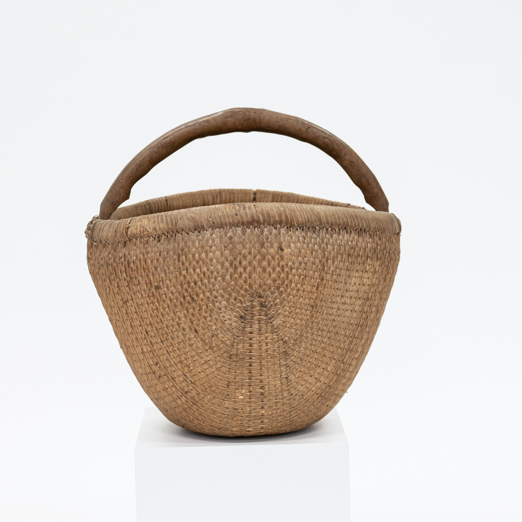 Woven basket with a handle on a white background