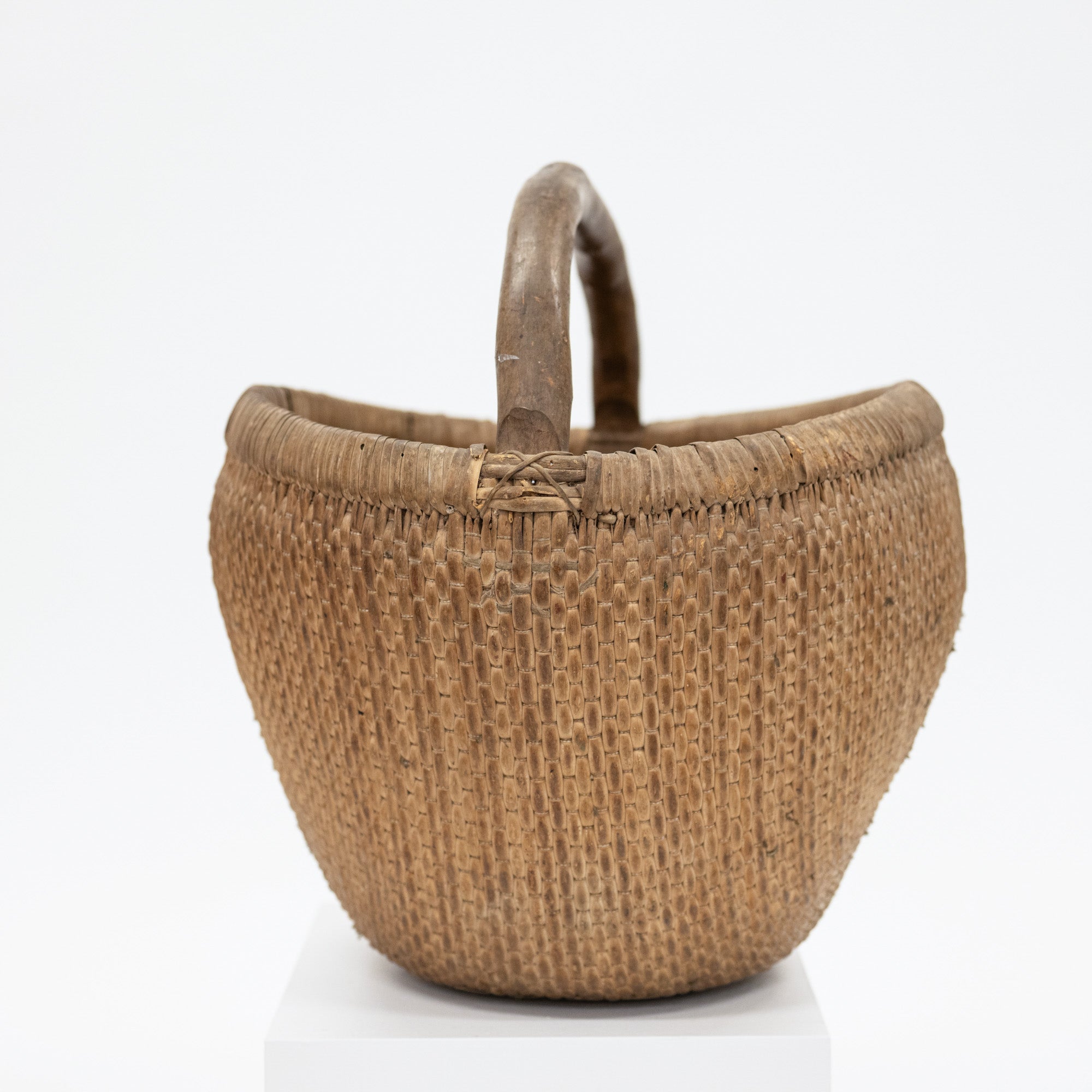 Woven basket with a handle on a white background
