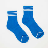 A pair of bright blue crew socks with white stripes on the cuffs and white trim on the toes, displayed on a clean white background.
