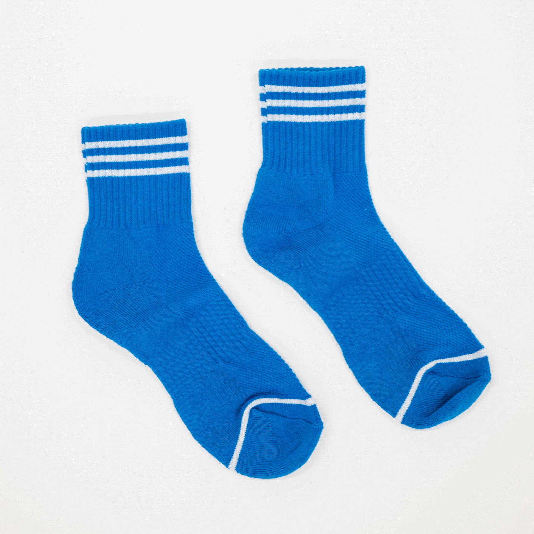 A pair of bright blue crew socks with white stripes on the cuffs and white trim on the toes, displayed on a clean white background.