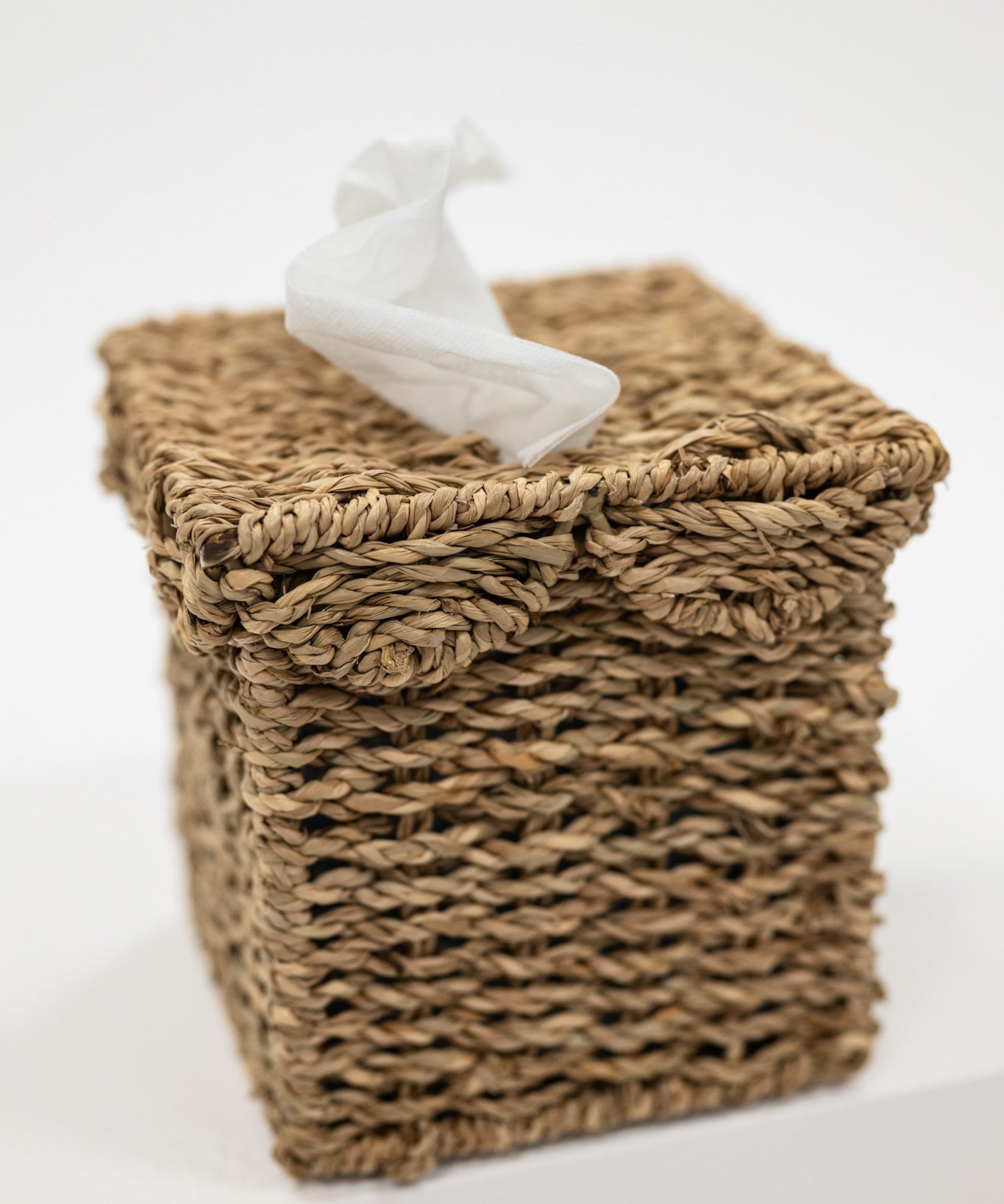 Woven basket with a white decorative figure on a light background
