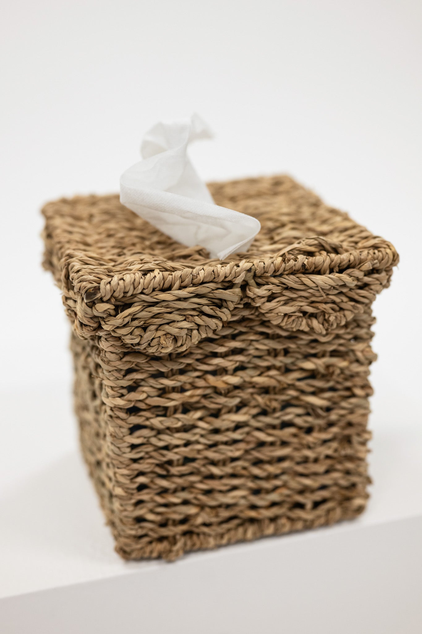 Woven basket with a white decorative figure on a light background
