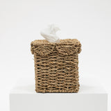 Woven tissue box cover with tissues on a white background