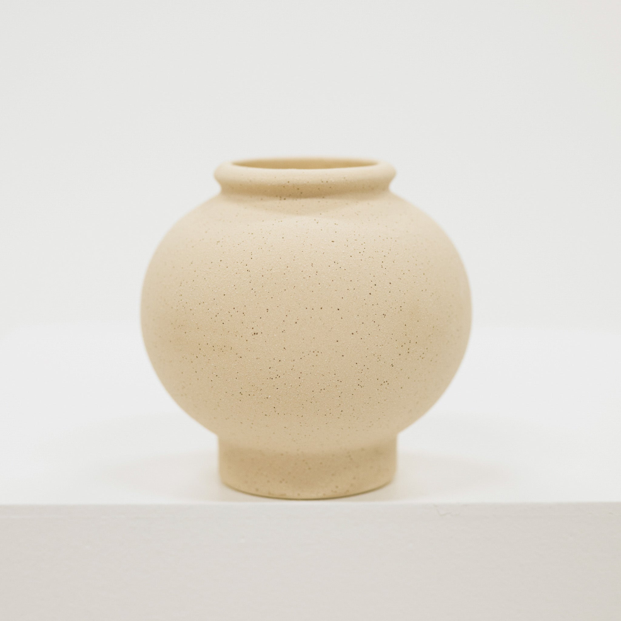 Cream ceramic vase on a light gray background