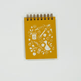 Yellow notebook with white illustrations on a light gray background