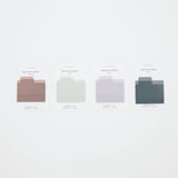 Four minimalist sticky note cards in muted dusty rose, pale sage green, light lavender, and dark slate blue, arranged in a row on a clean white background.